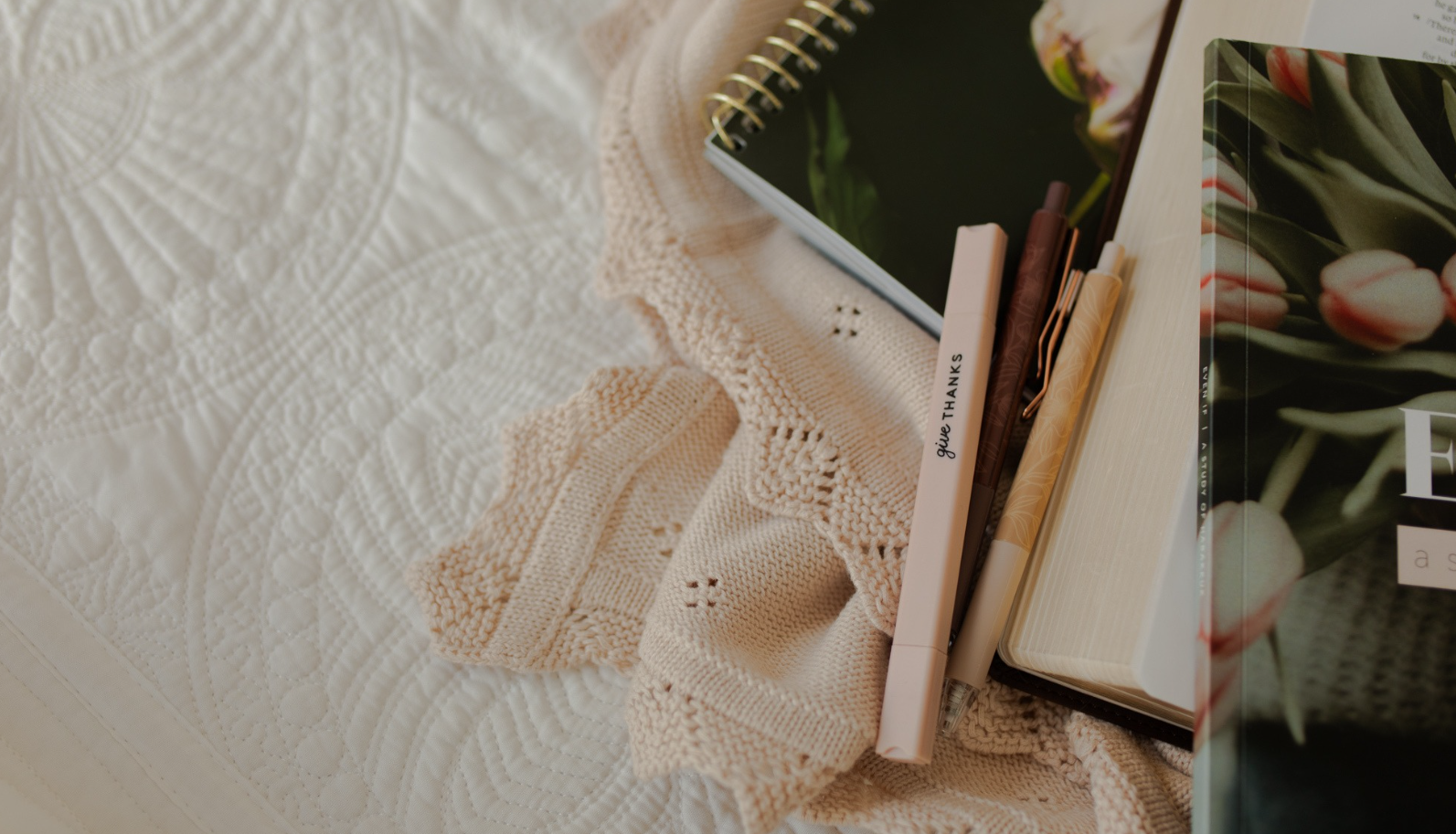 Multiple Daily Grace studies and pens on a white blanket