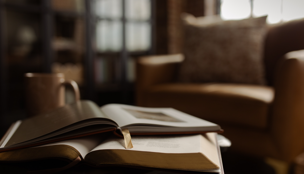 An open book on an open bible with a armchair in the background