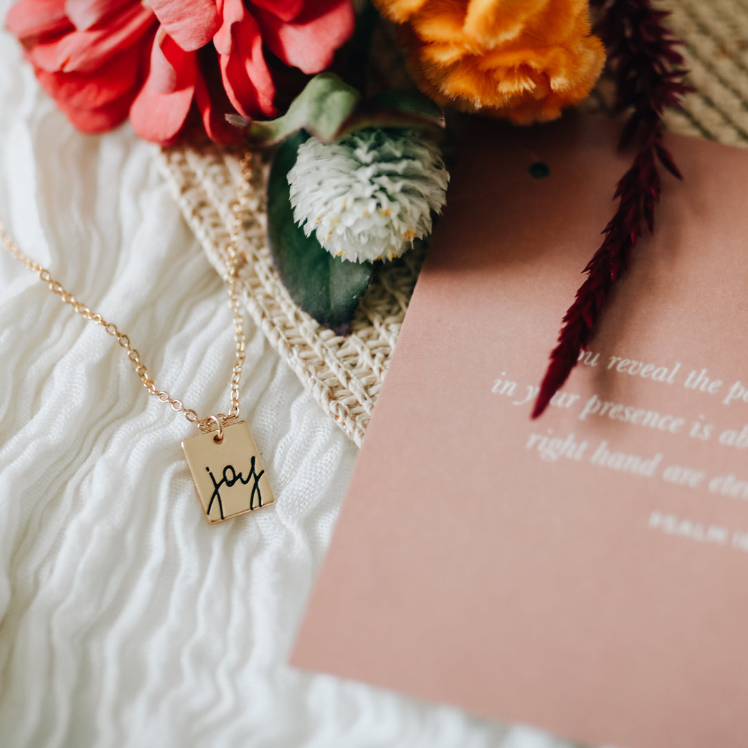 Necklace on scarf next to flowers