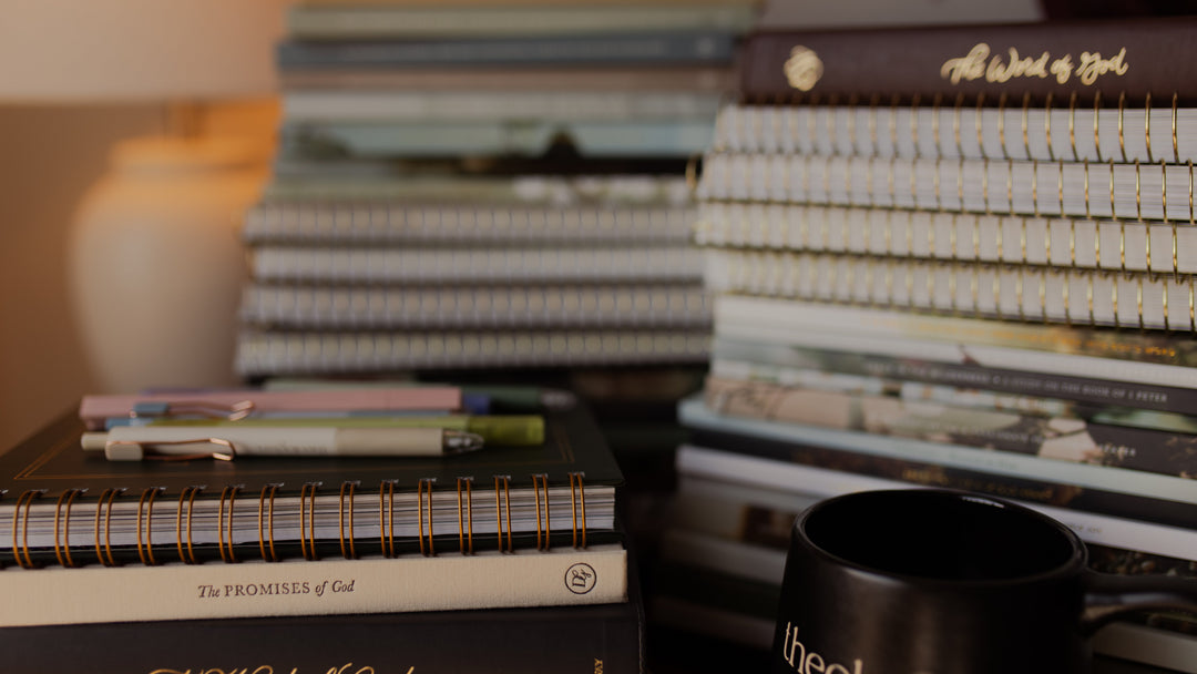 Stacks of multiple bible studies next to a coffee cup