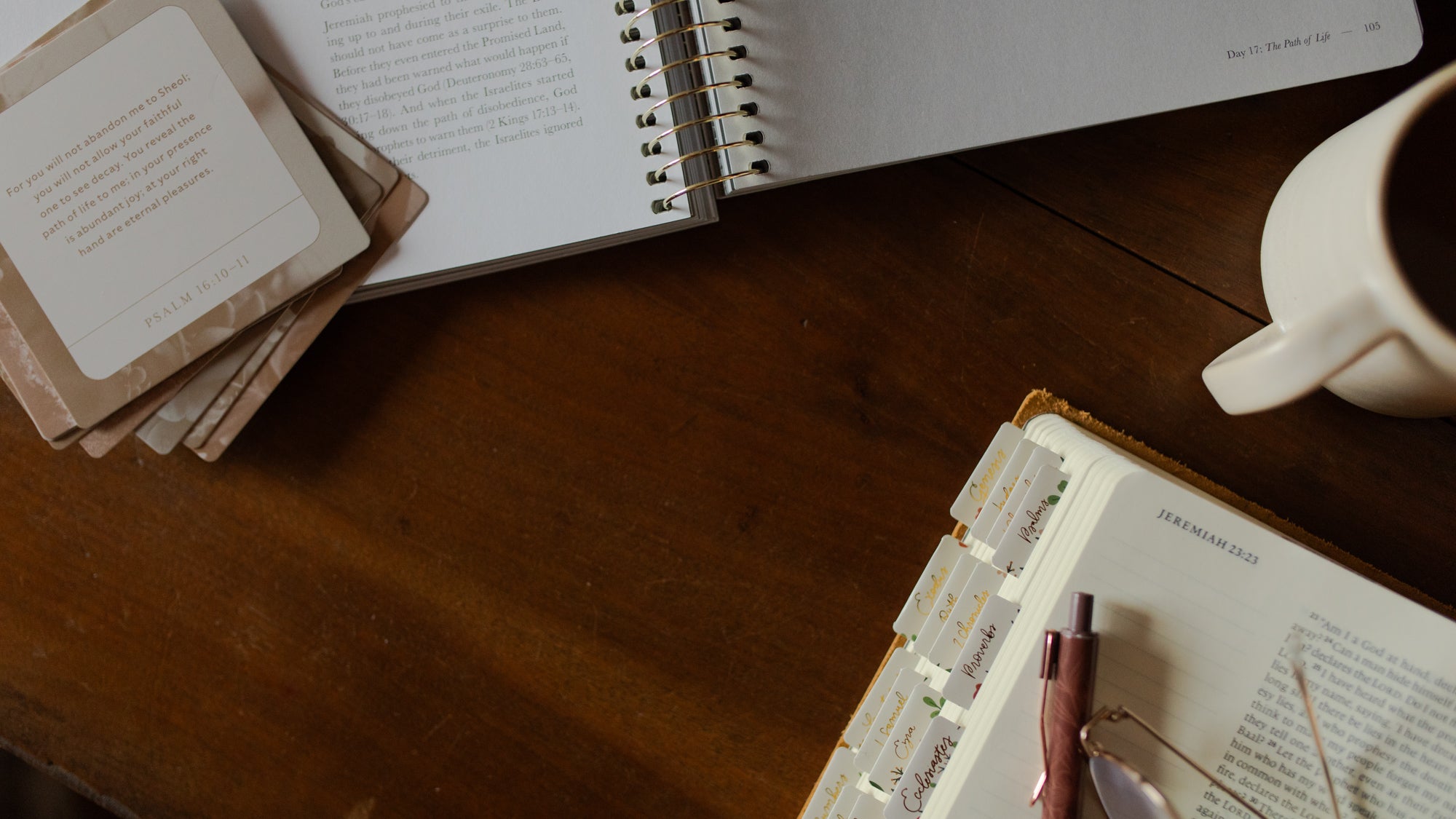 An open bible study and an open Bible on a wooden table