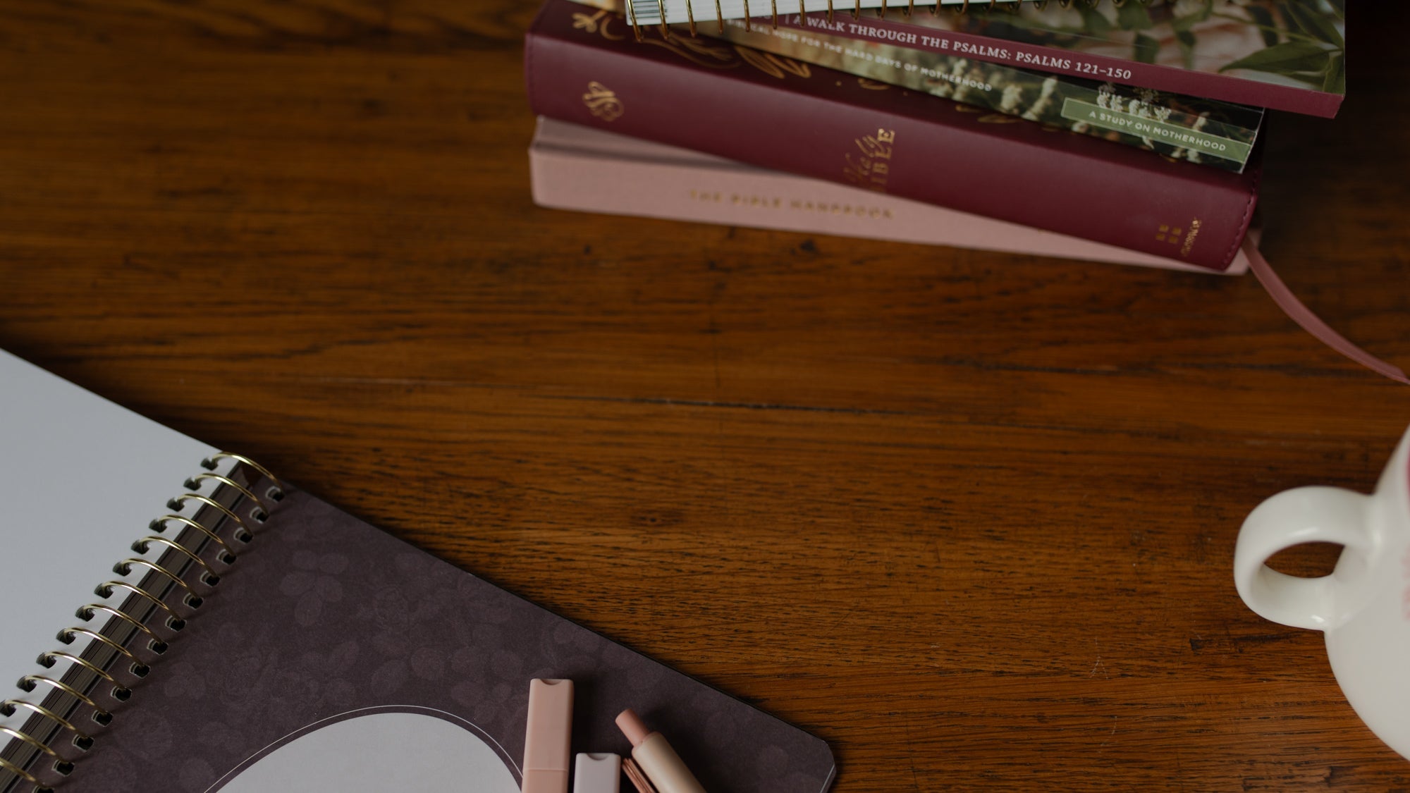 A spiral and a softcover on a white blanket