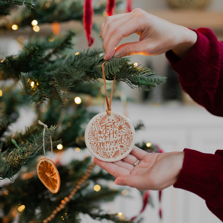 Woman hanging Advent Christmas ornament on tree