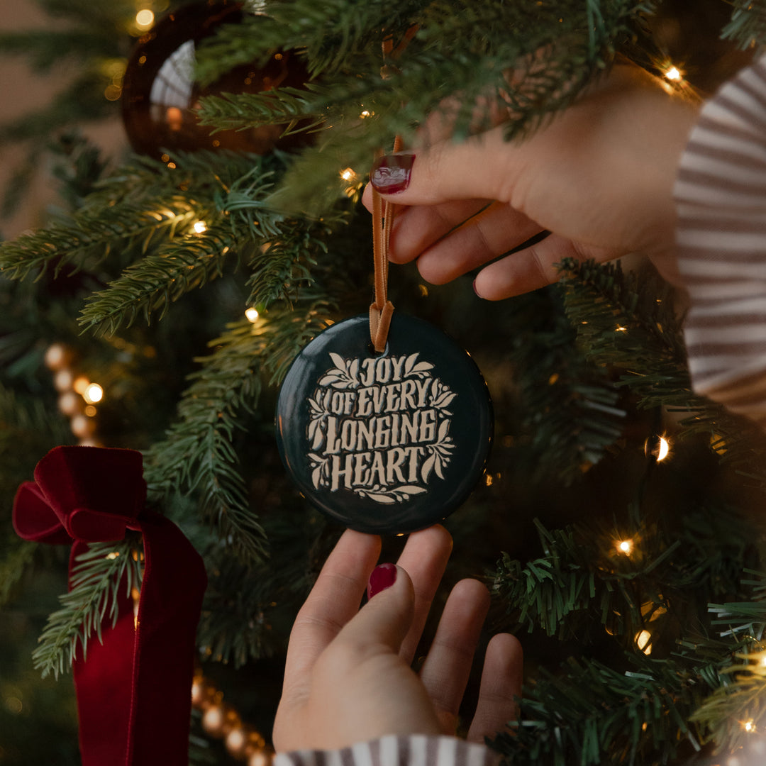 Up close of A woman holding the A Joy of Every Longing Heart Ornament