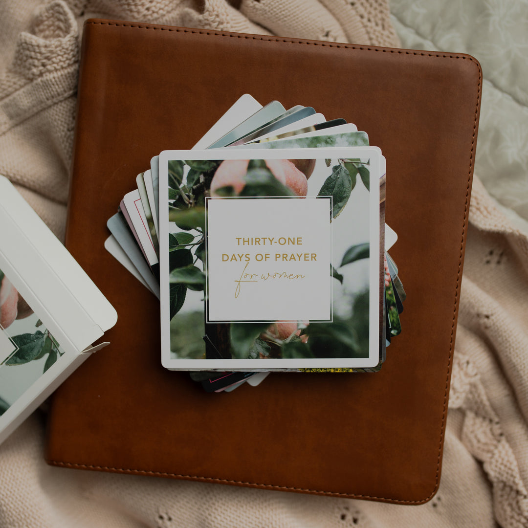 The 31 Days of Prayer cards stacked on a leather bible on a cream colored cloth