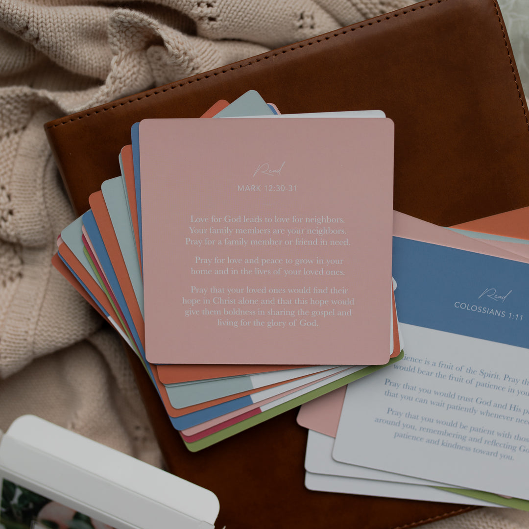 The back of the 31 Days of Prayer cards stacked on a leather bible on a cream colored blanket