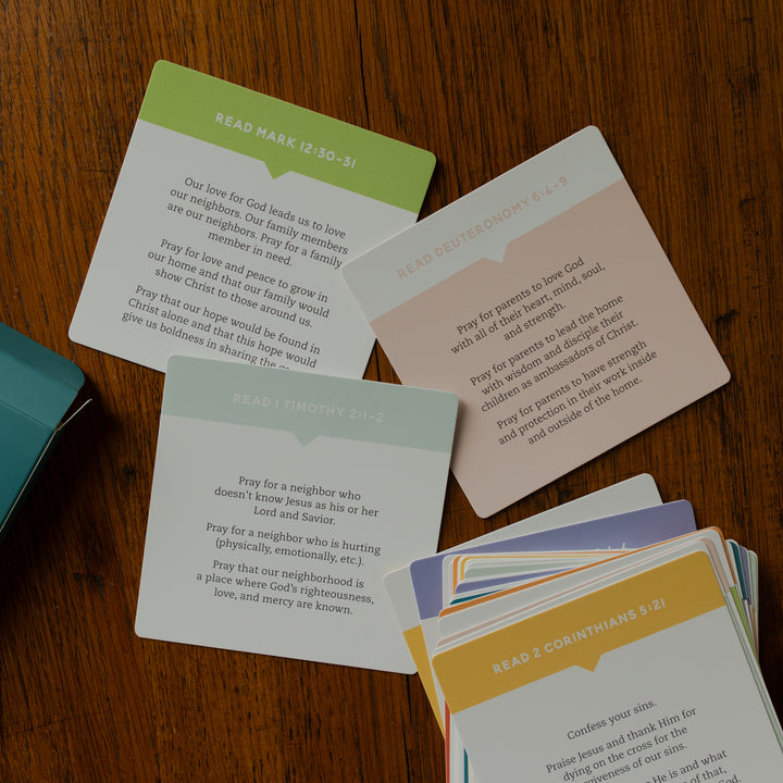The back of the 31 Days of Prayer for Kids Verse Cards scattered on a wooden table