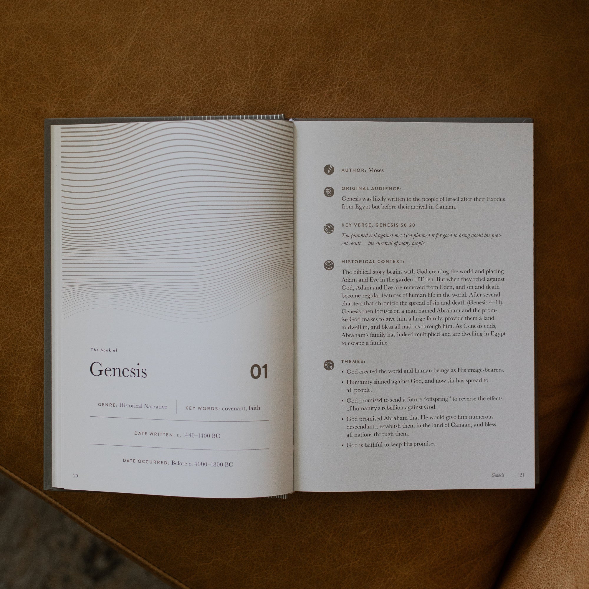 A Year in the Bible Hardcover opened to the Genesis beginning page on a leather couch