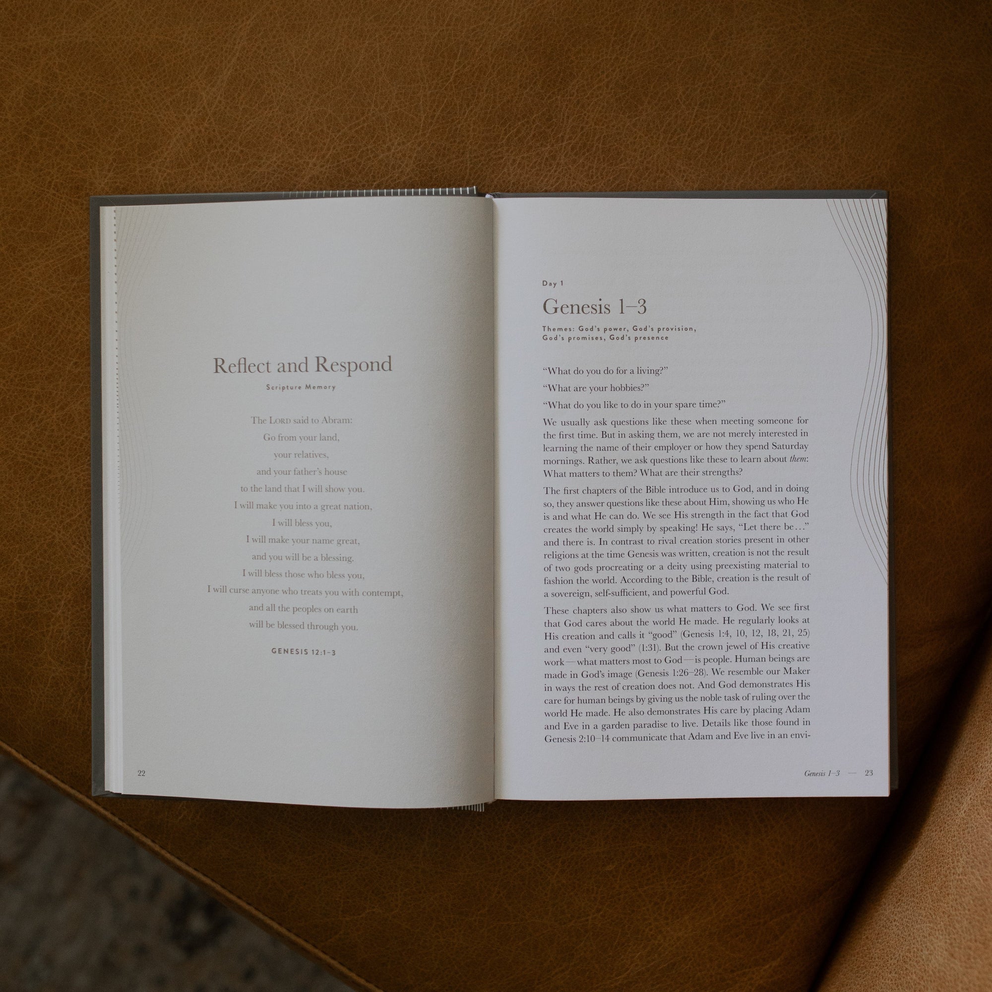 A Year in the Bible Hardcover opened to the Genesis Reflect and respond page on a leather couch