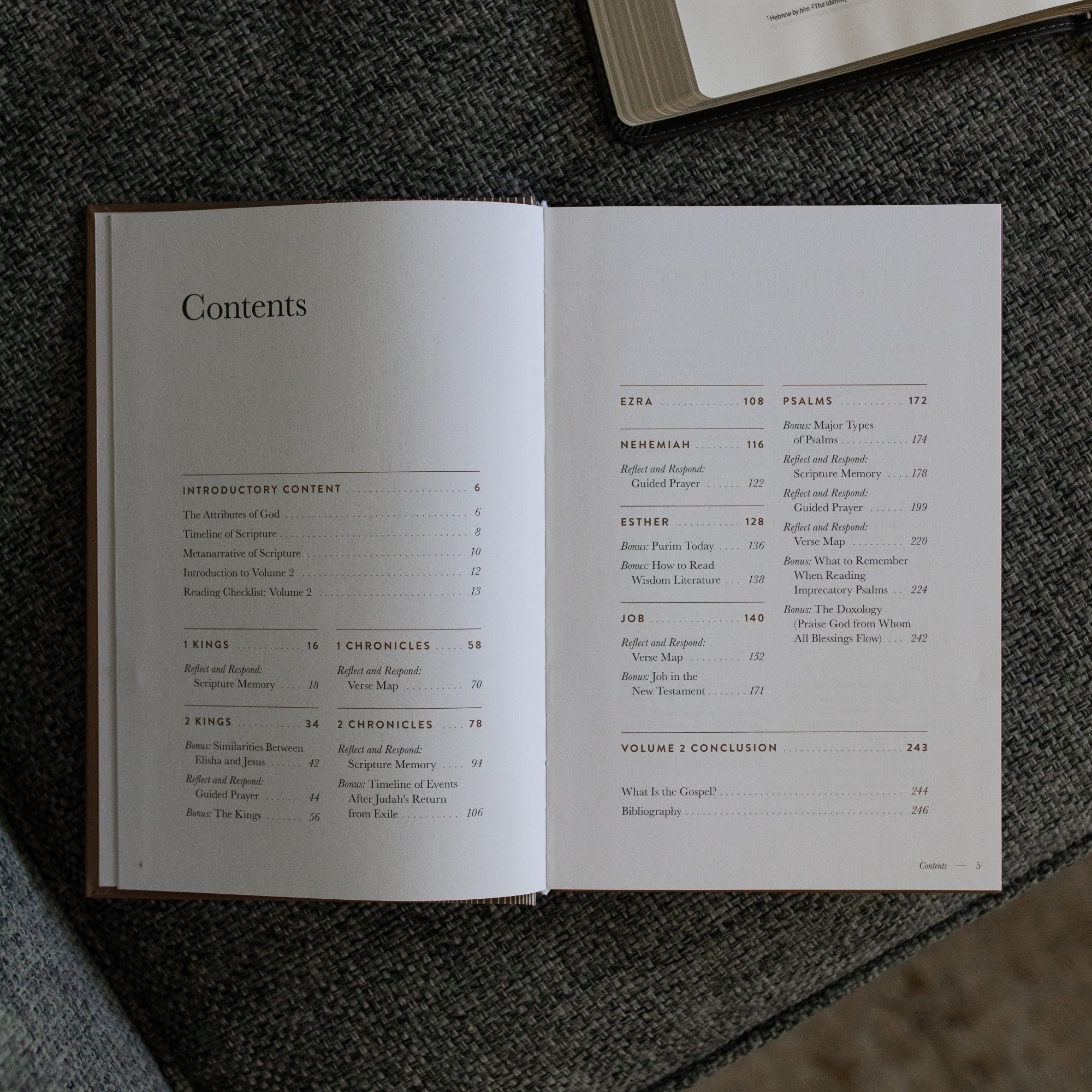 A Year in the Bible Mens Study opened to the table of contents page on a gray couch cushion