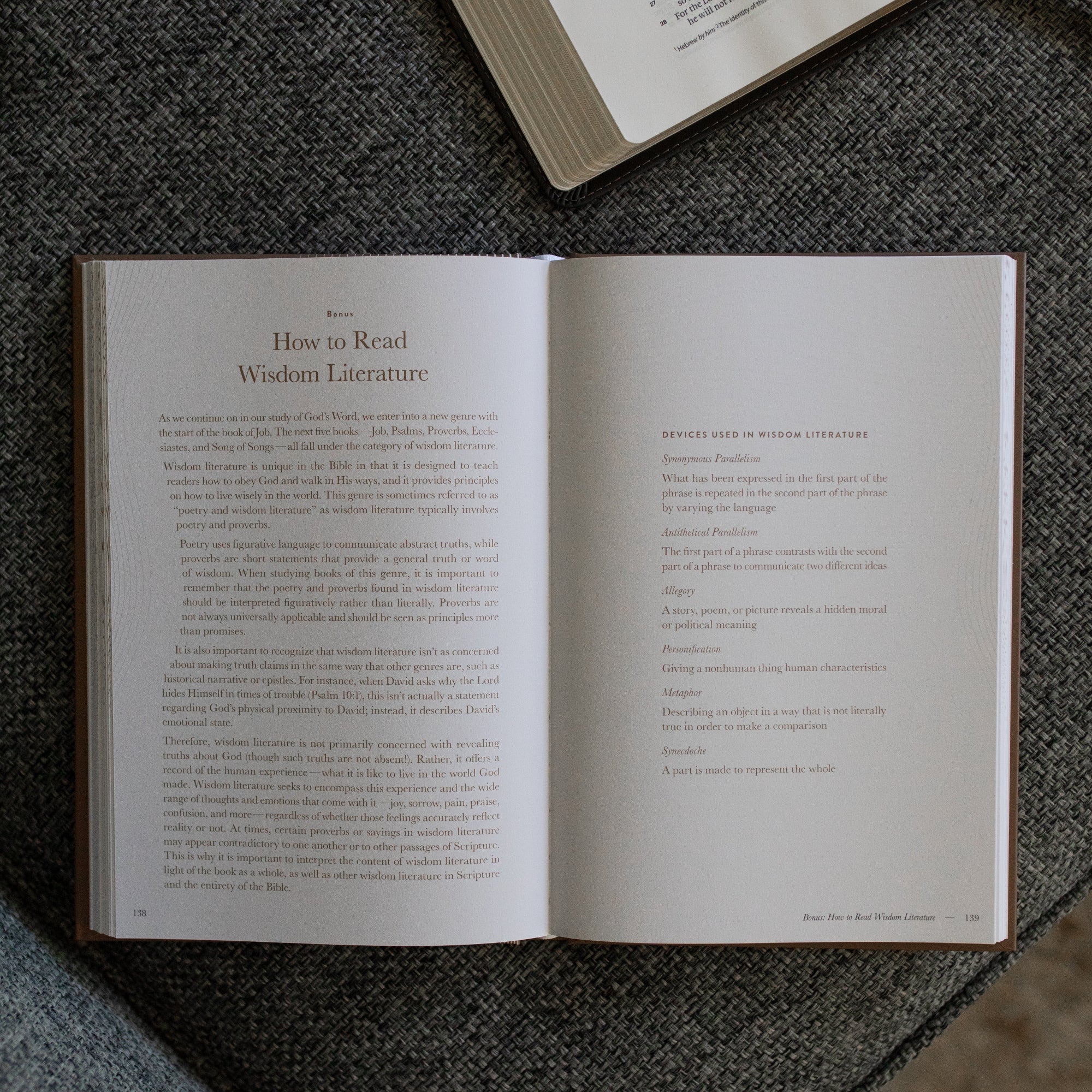 A Year in the Bible Mens Study opened to the How to Read Wisdom Literature page on a gray couch cushion