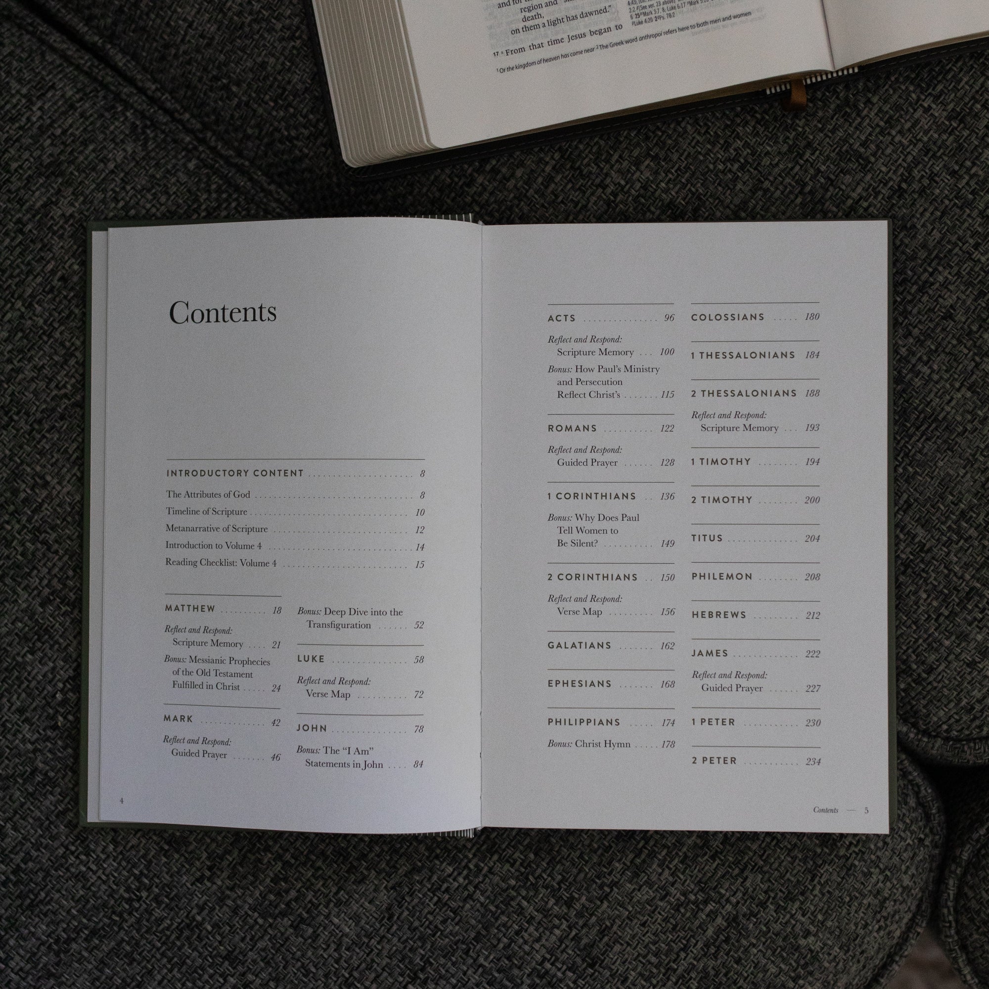 A Year in the Bible Vol 4 Hardcover opened to the contents page near an open bible on a grey couch cushion