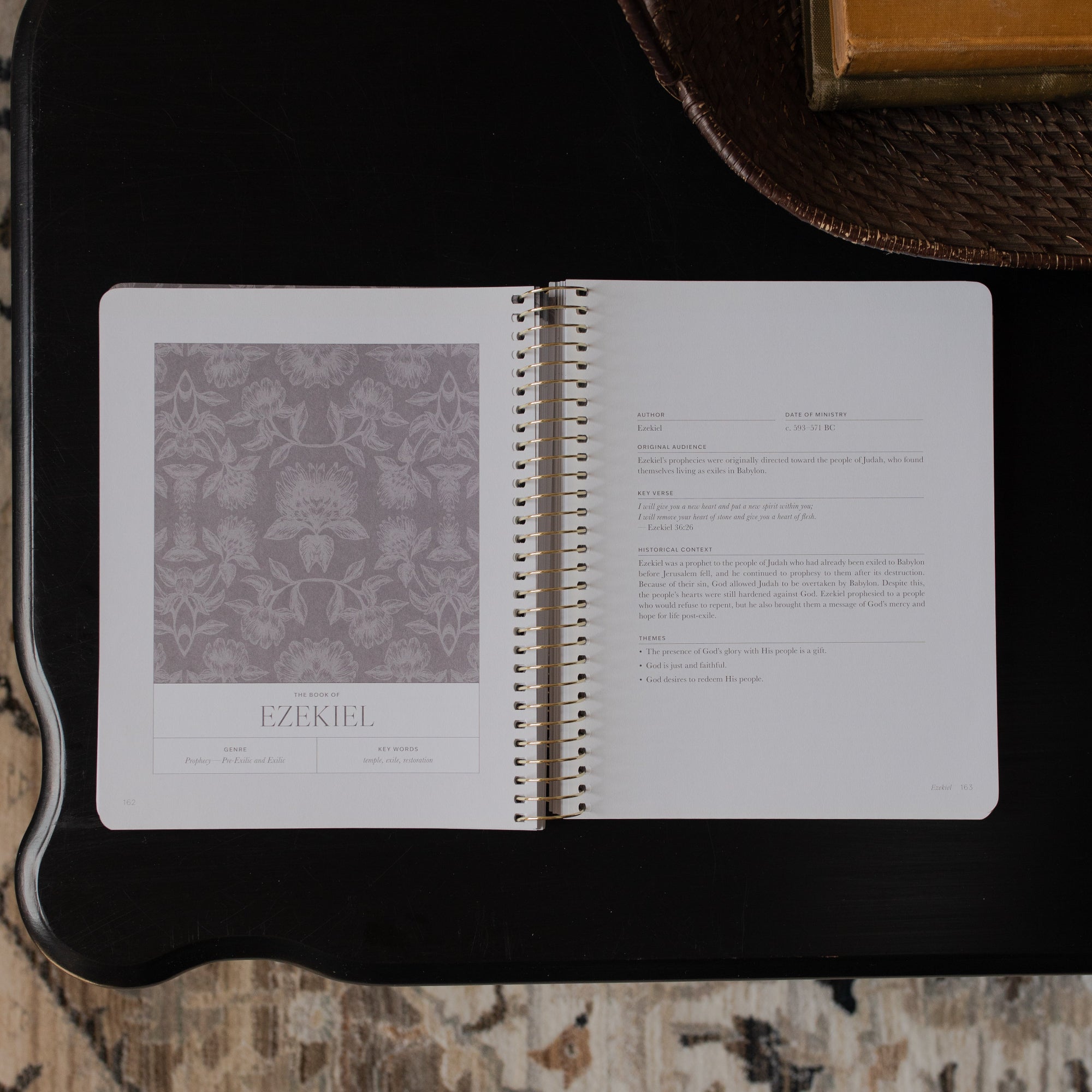 A Year in the bible Vol 3 opened to the Ezekiel beginning page on a black tabletop
