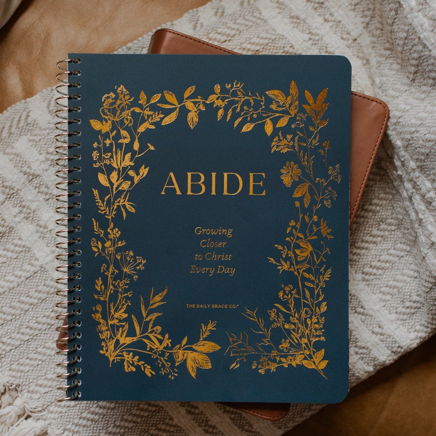 The Abide Spiral on a closed bible on a cream colored blanket