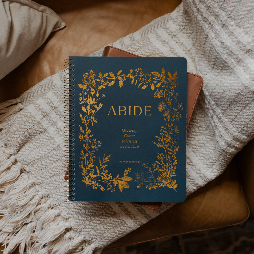 The Abide Spiral on a closed bible on a cream colored blanket