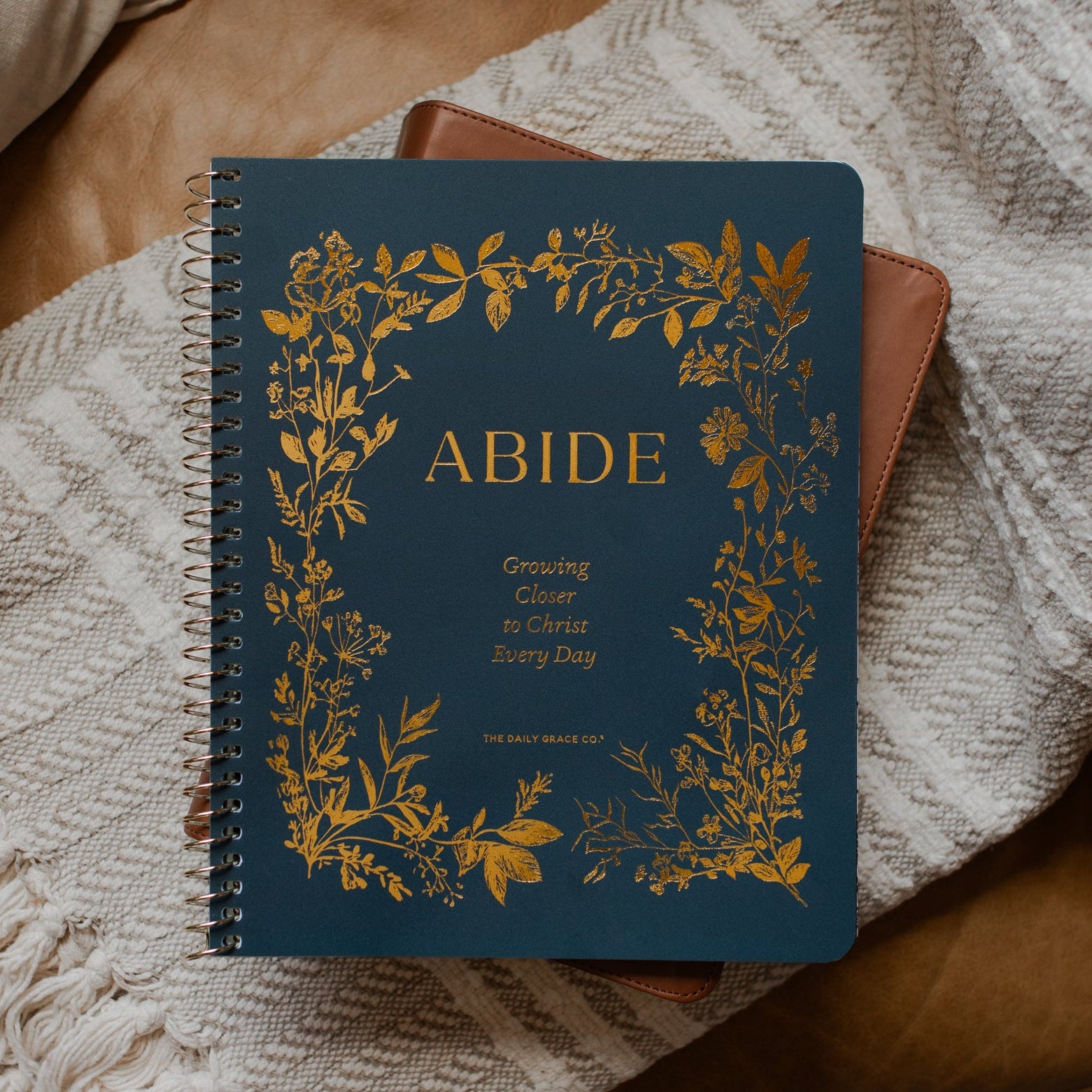 The Abide Spiral on a closed bible on a cream colored blanket