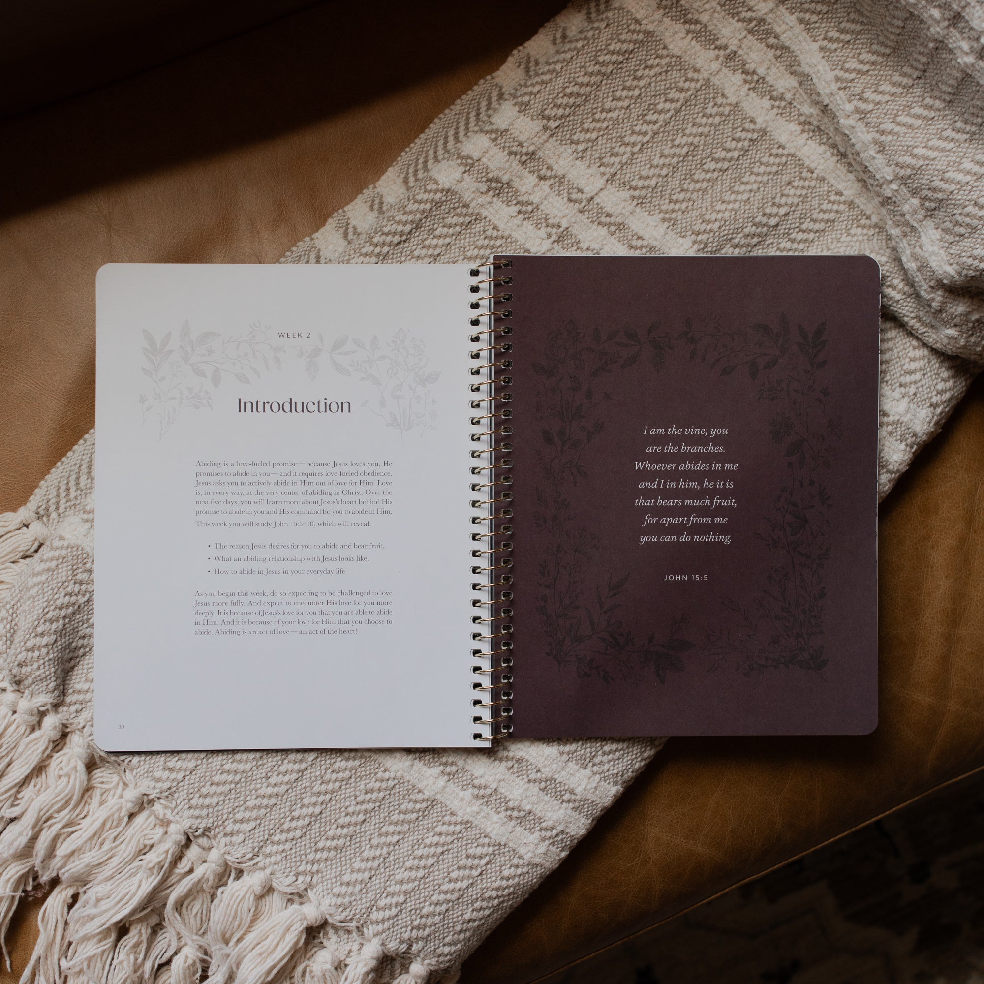 The Abide Spiral opened to the Week 2 Introduction page on a cream colored blanket