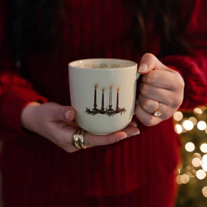 A woman holding the Advent Adventure Mug facing the camera