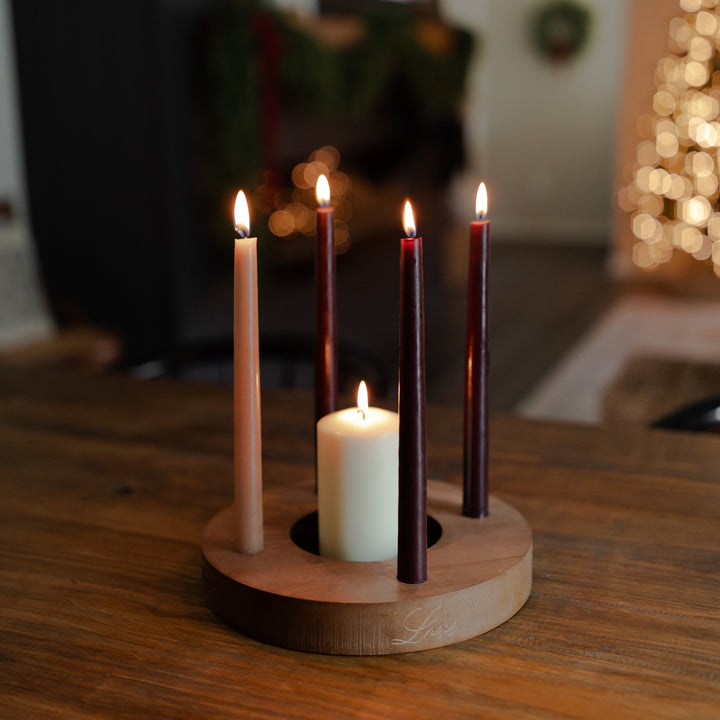 Wooden Candle holder with 5 lit candles sitting on a wooden desk with the word Love engraved on the side