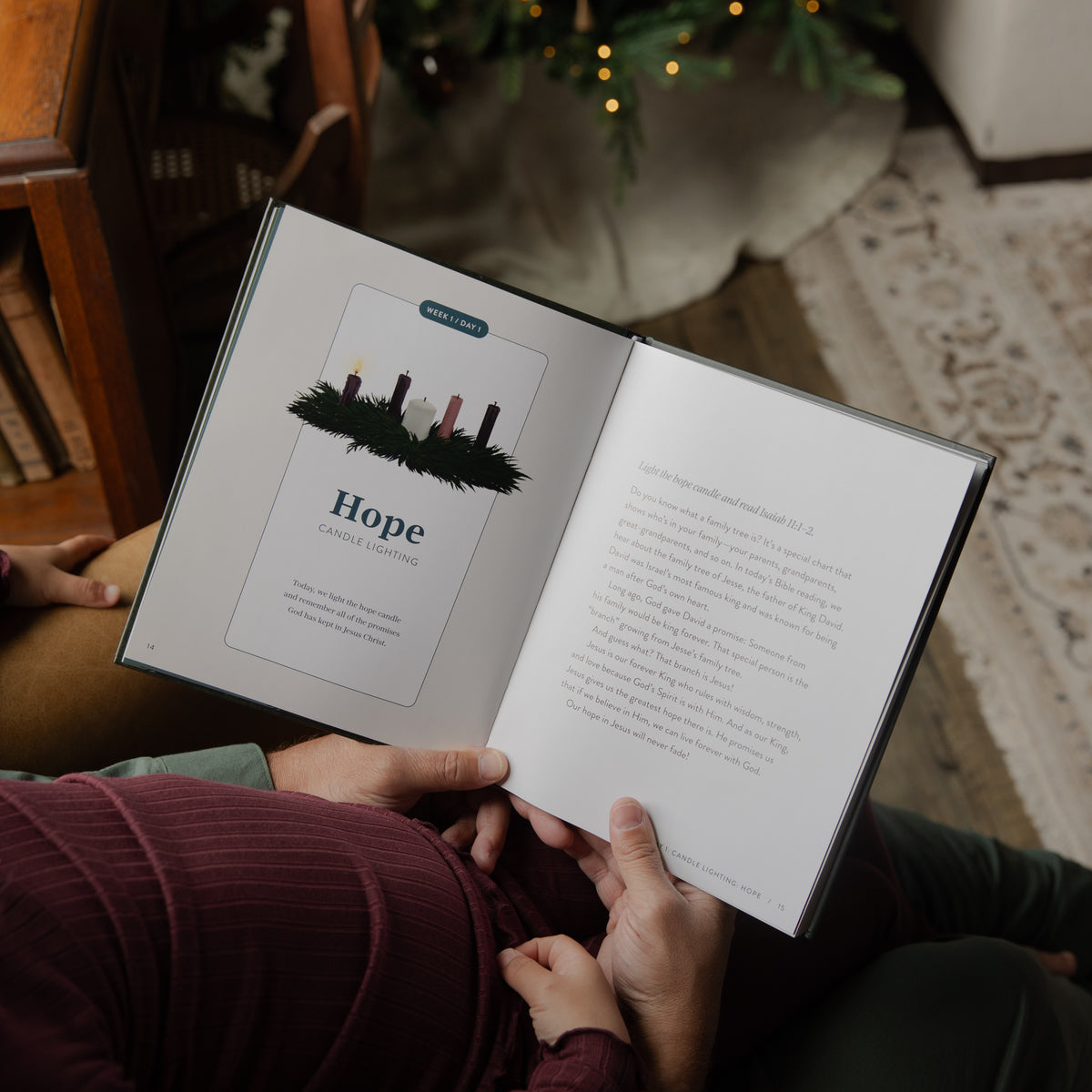 An open storybook with a chapter titled 'Hope' being held by hands in a cozy indoor setting, with a Christmas tree and warm lights blurred in the background.