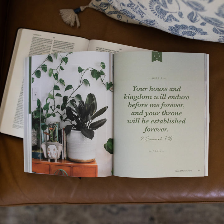Amen from Eden to Eternity Matte Study opened to Week 3 memory verse page laying on an open bible on a brown leather couch next to a white and blue decorated pillow