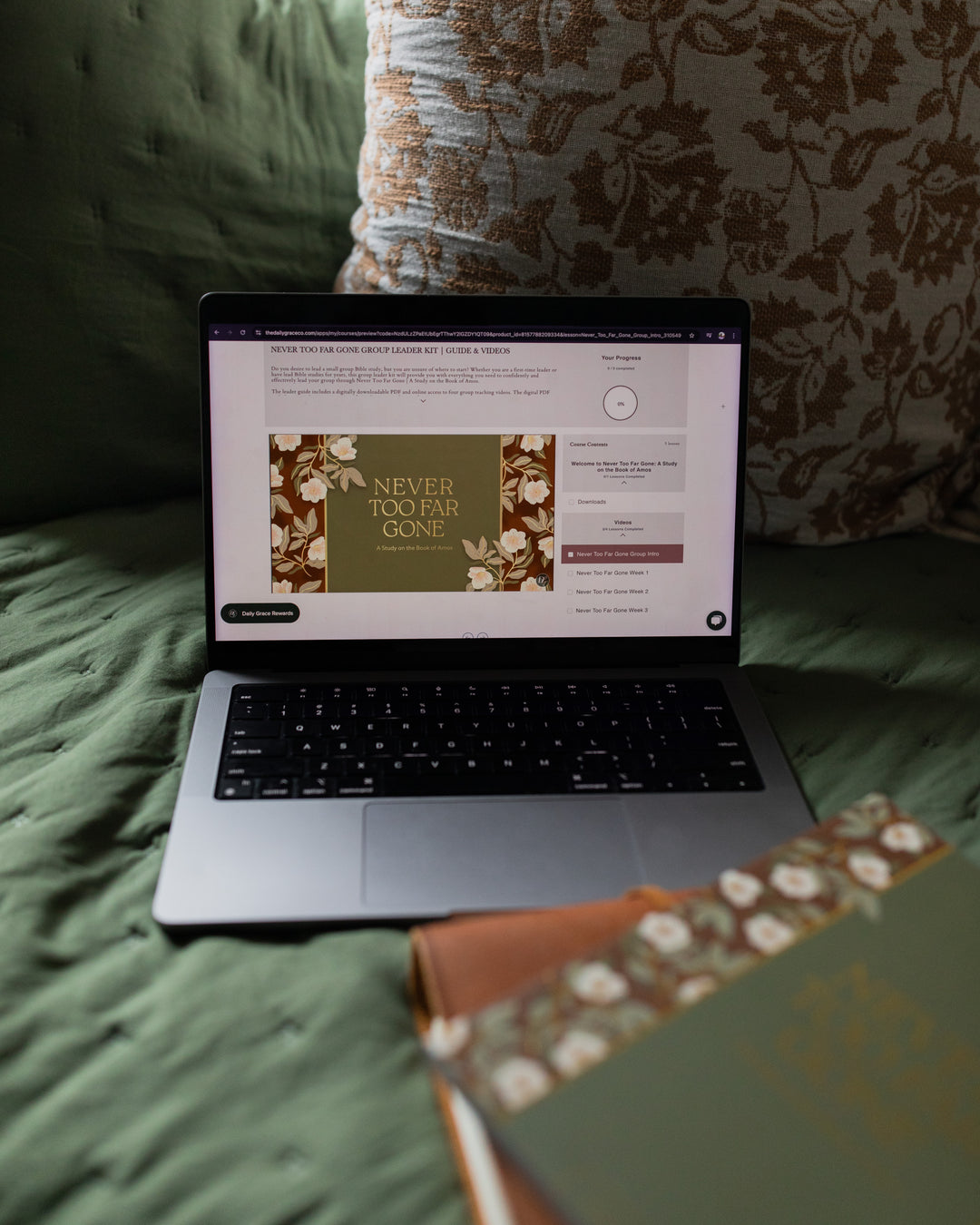 Group leader guide displayed on a laptop on a green couch with the Bible study and a Bible