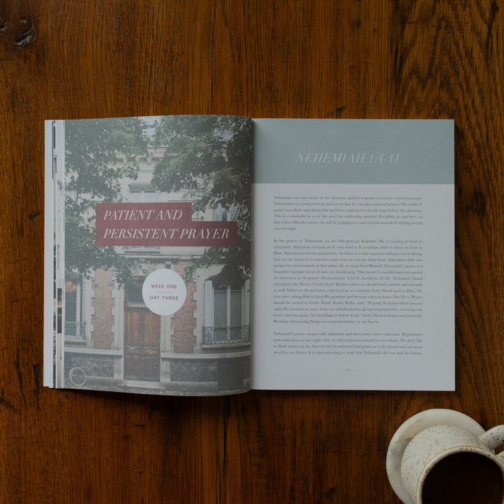 Open book on a wooden surface with text and a building illustration.