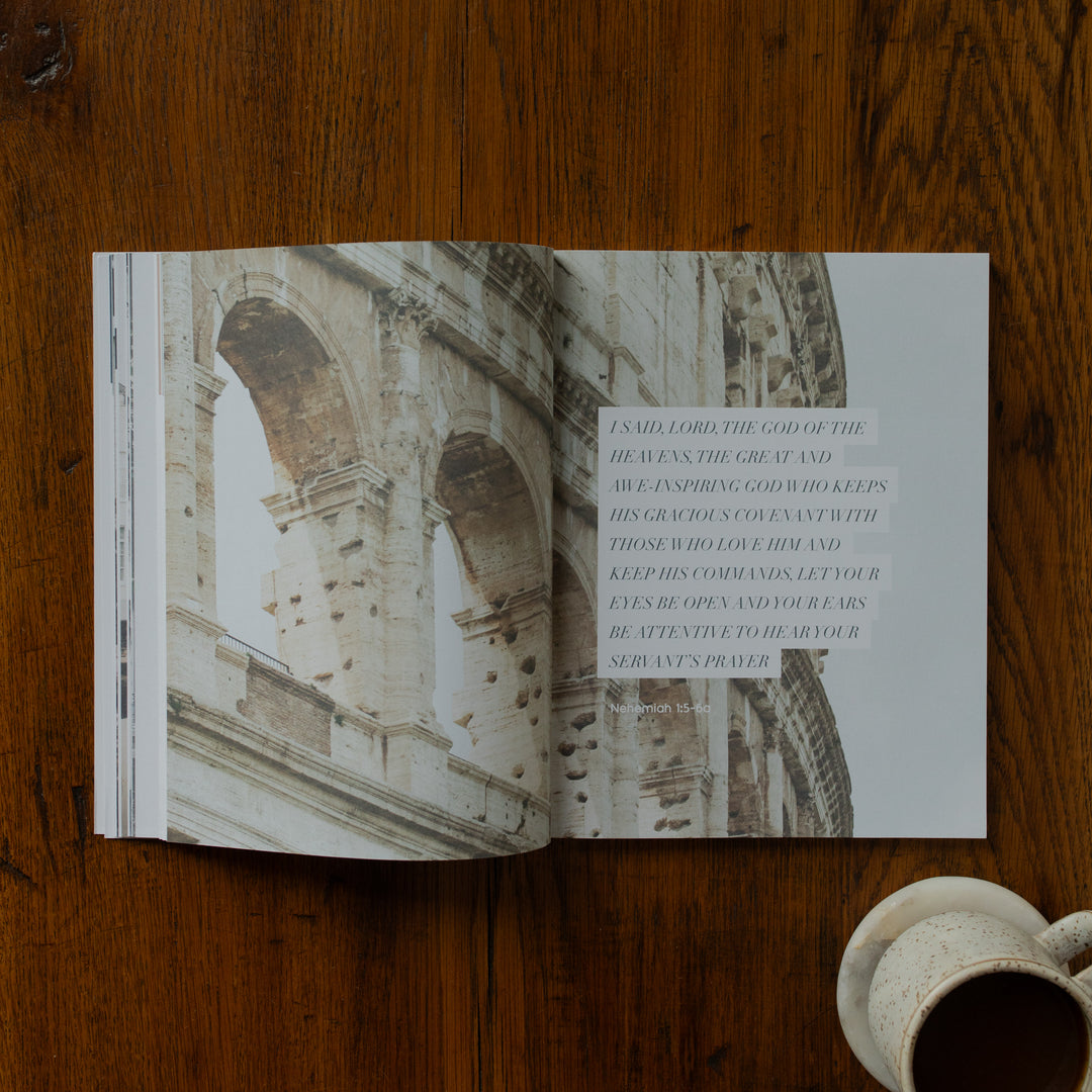 Open book with architectural photograph and text on a wooden surface