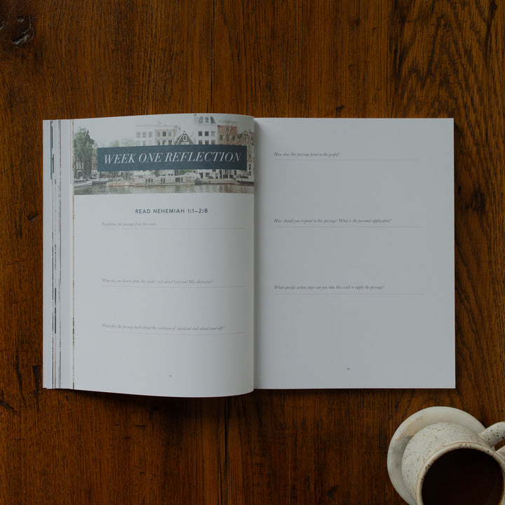Open book on a wooden surface with a cup of coffee.