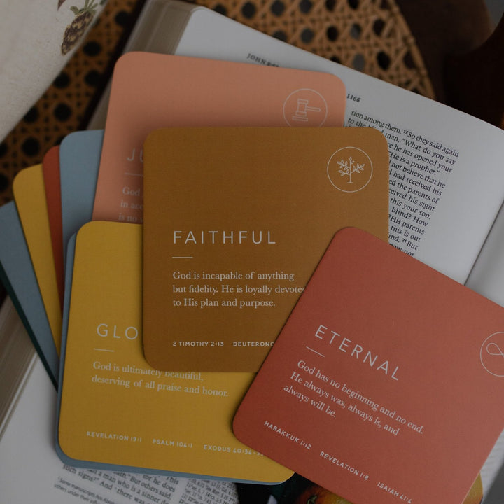 Multiple fronts of Attributes of God Cards spread out on top of a Bible