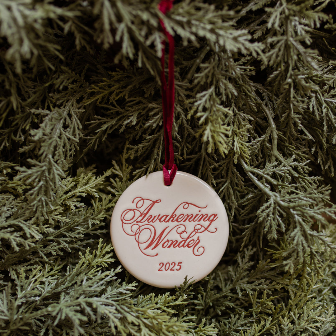 Decorative ornament with 'Awakening Wonder 2025' text on some branches