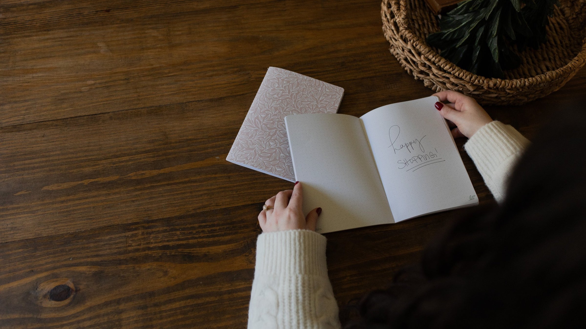 Woman with a journal opened on a wooden table