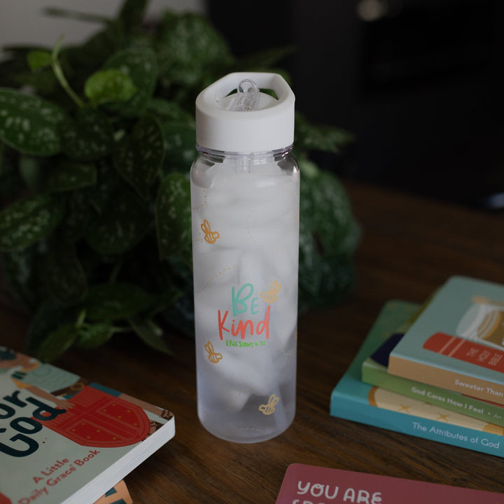 Be Kind clear kids water bottle on a table. 