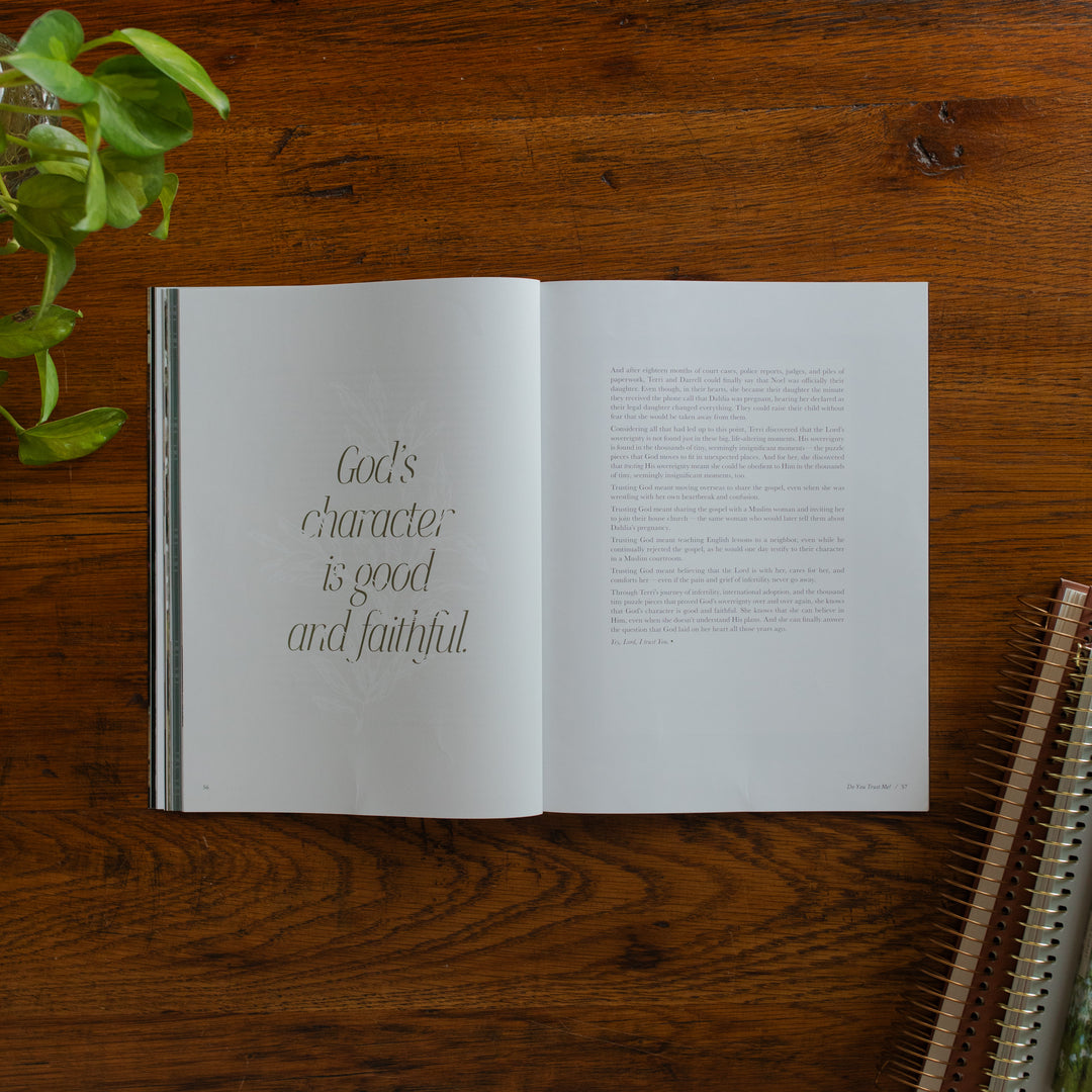 Be Still Issue 40 Magazine opened to the Gods character is good and faithful page on a wooden table near some greenery