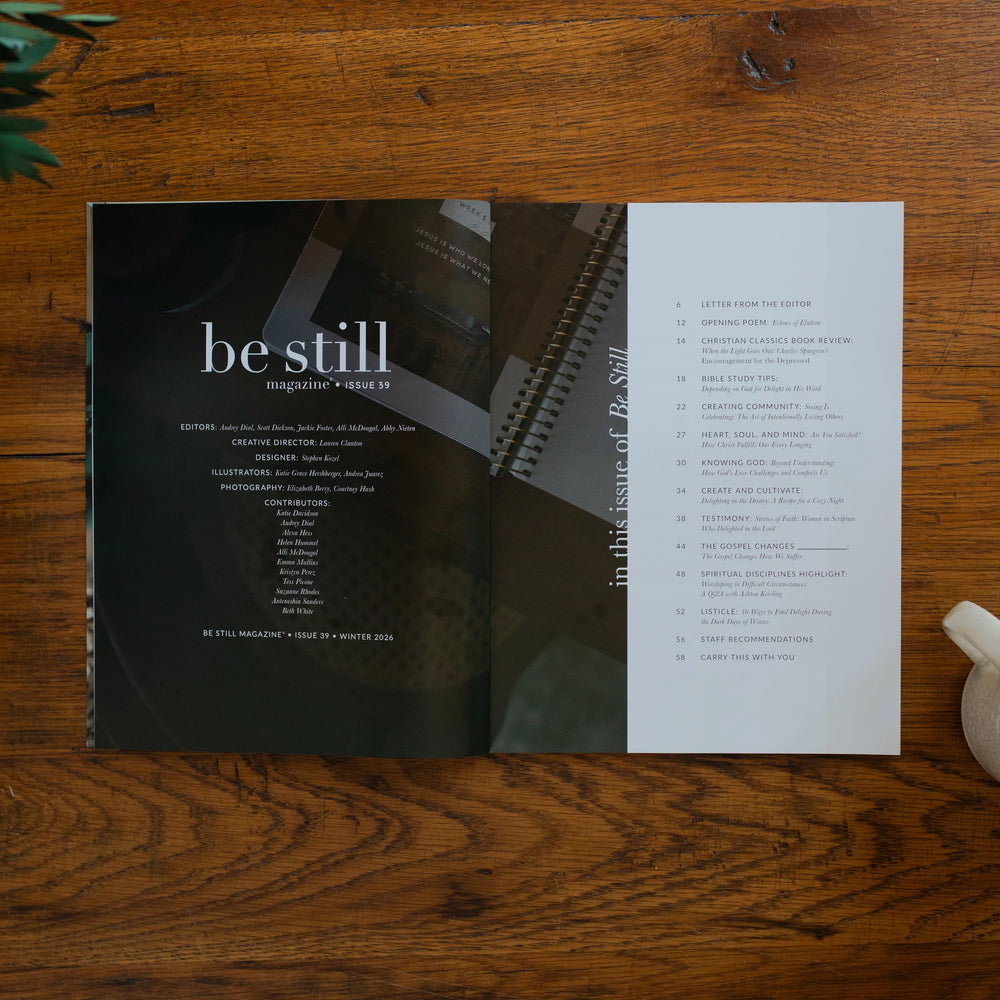Be Still Magazine Issue 39 opened to the table of contents on a wooden table next to a coffee cup