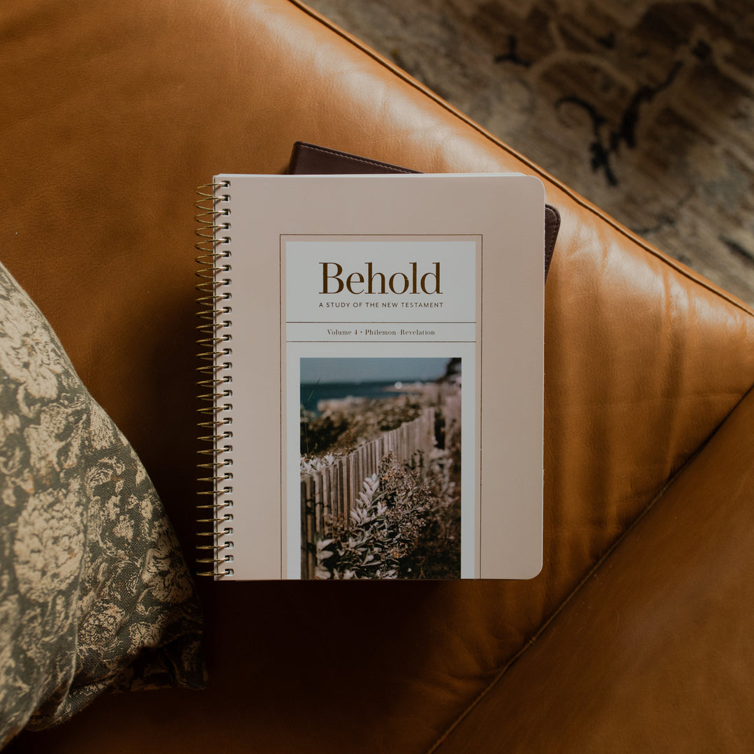 Behold Spiral Study cover on a closed bible on a leather couch