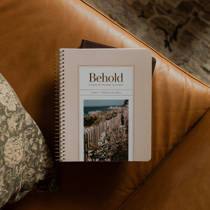 Behold Spiral Study cover on a closed bible on a leather couch