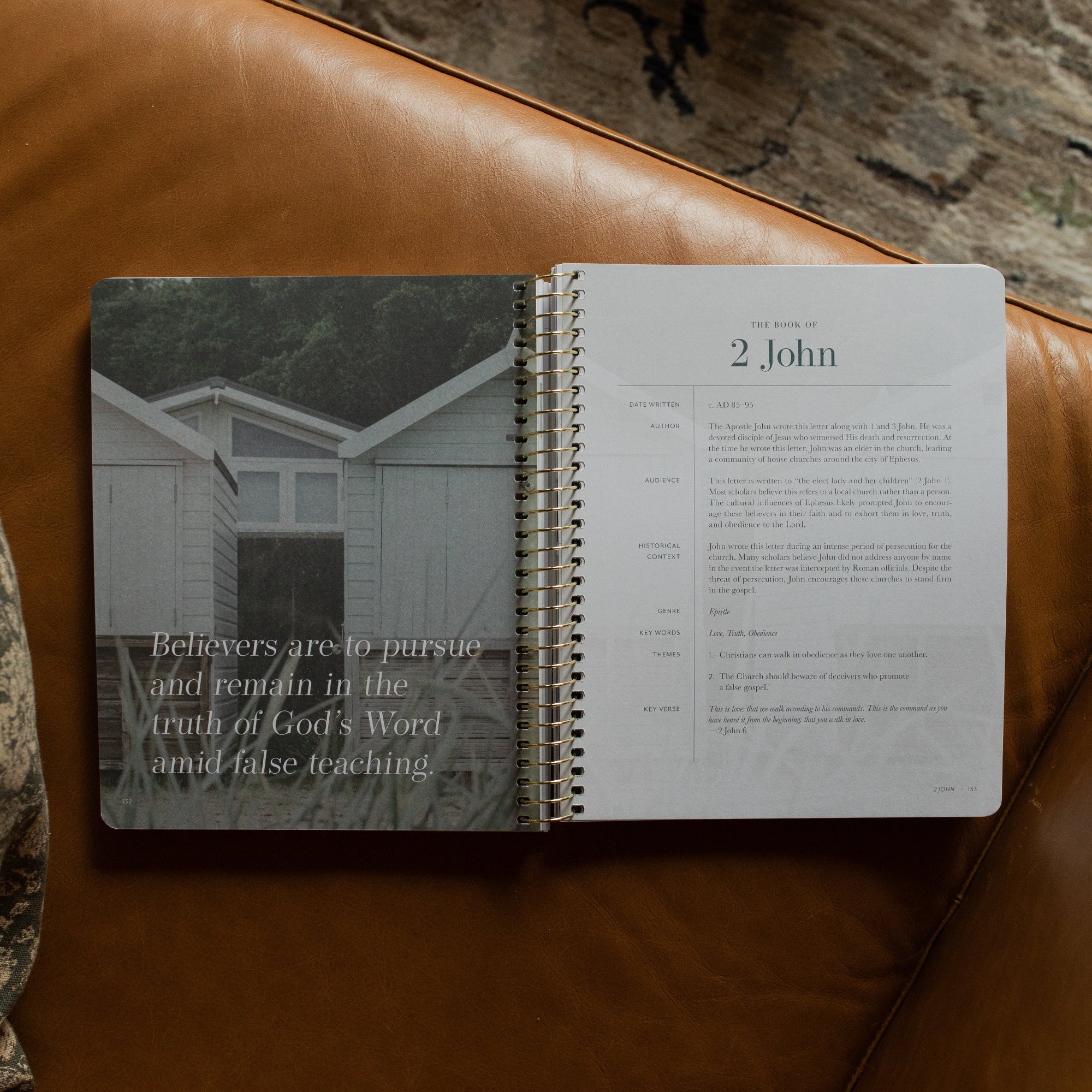 Behold Spiral Study opened to the 2 John page on a leather couch