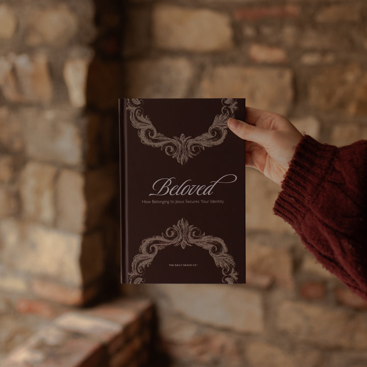A woman holding the Beloved How belonging to Jesus Secures your Identity near a brick wall