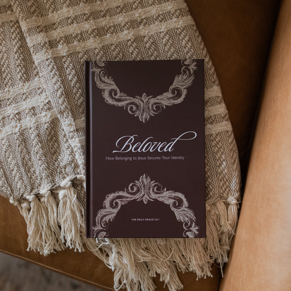 The Beloved How Belonging to Jesus Secures your Identity book cover resting on a brown leather couch and a knitted blanket