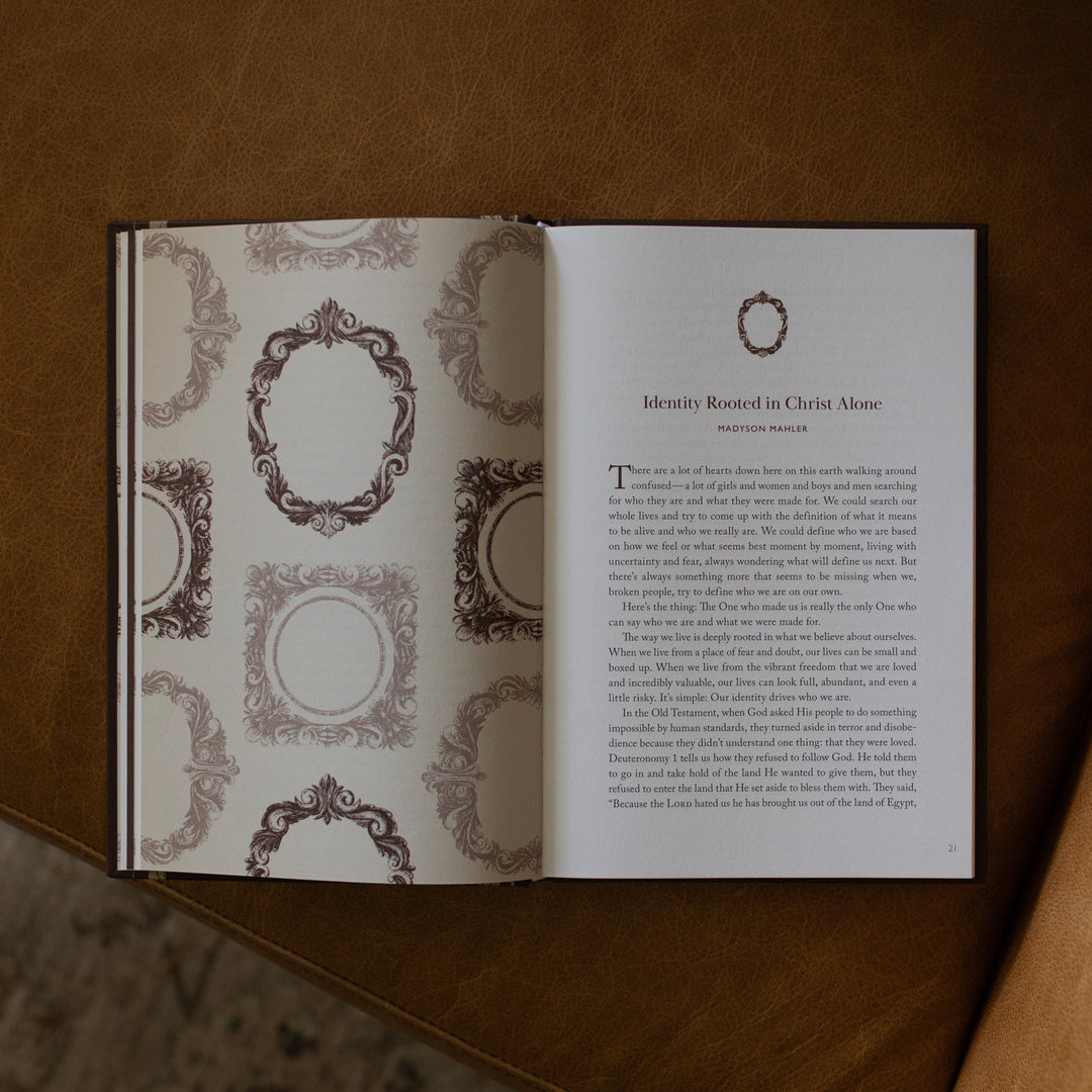 The Beloved How Belonging to Jesus Secures your Identity book opened to the Identity Rooted in Christ Alone page resting on a brown leather couch