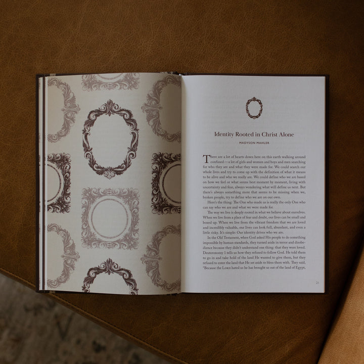 The Beloved How Belonging to Jesus Secures your Identity book opened to the Identity Rooted in Christ Alone page resting on a brown leather couch