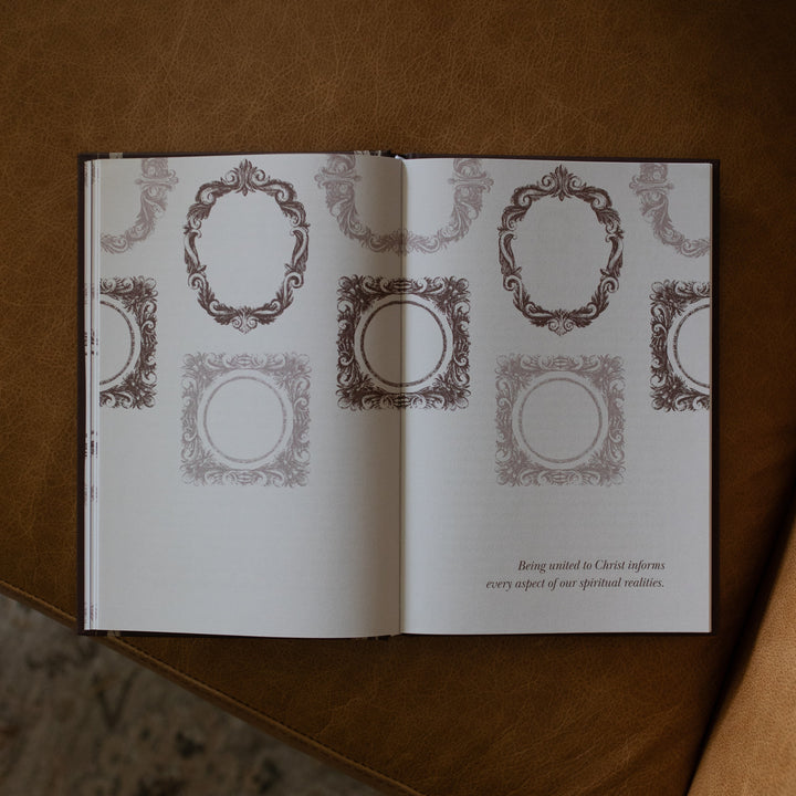 The Beloved How Belonging to Jesus Secures your Identity book opened to the Being United to Christ informs every aspect of our spiritual realities page resting on a brown leather couch