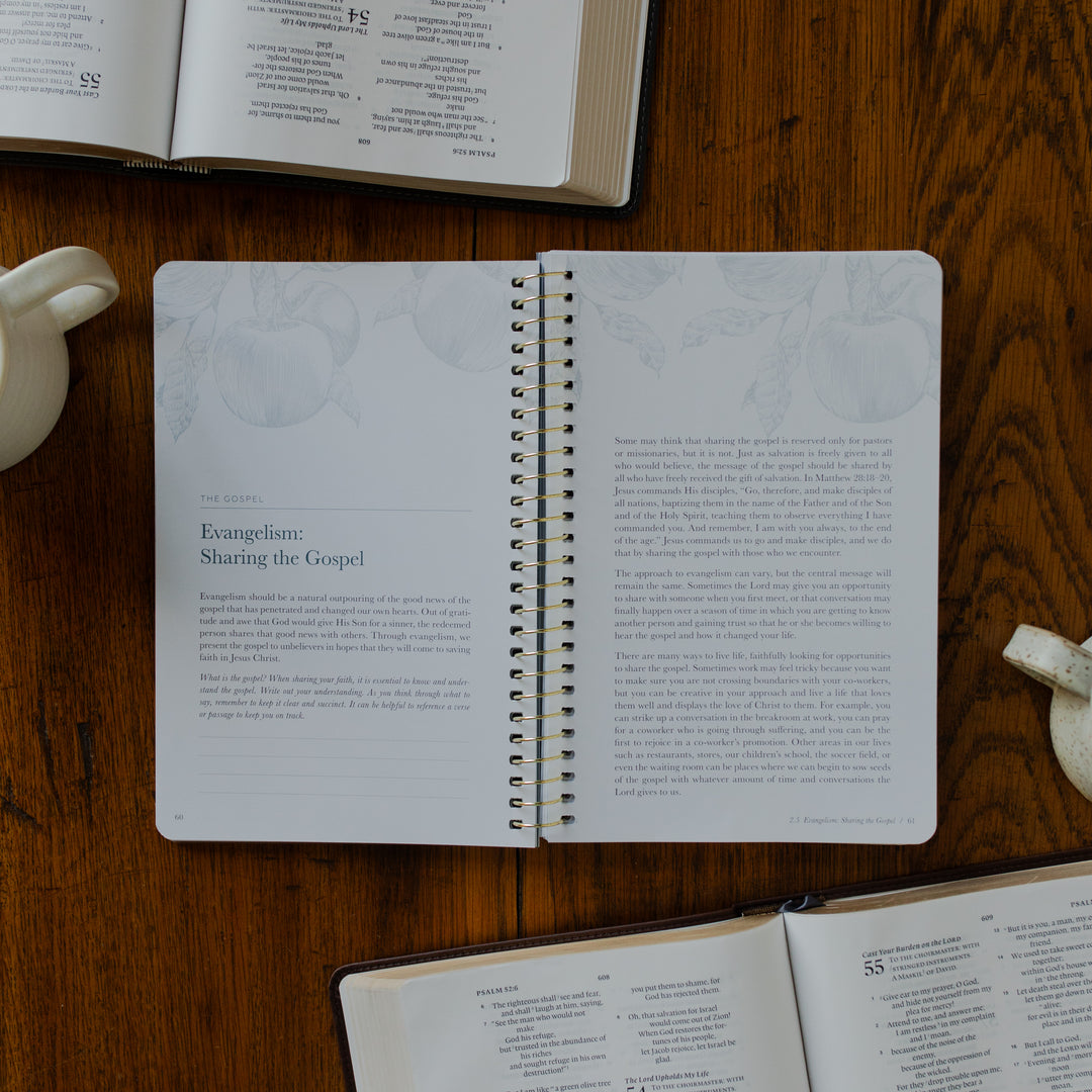 The Better Together Discipleship Guide opened to the Evangelism Sharing he Gospel page on a wooden surface