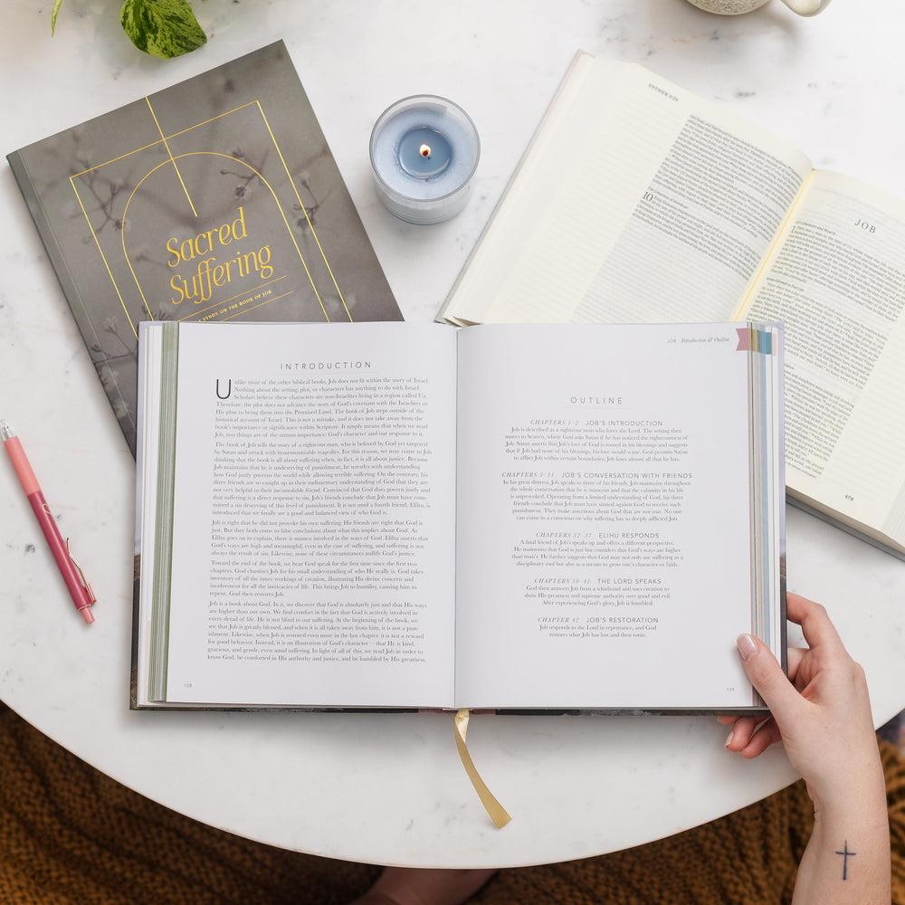 Women holding handbook open on table