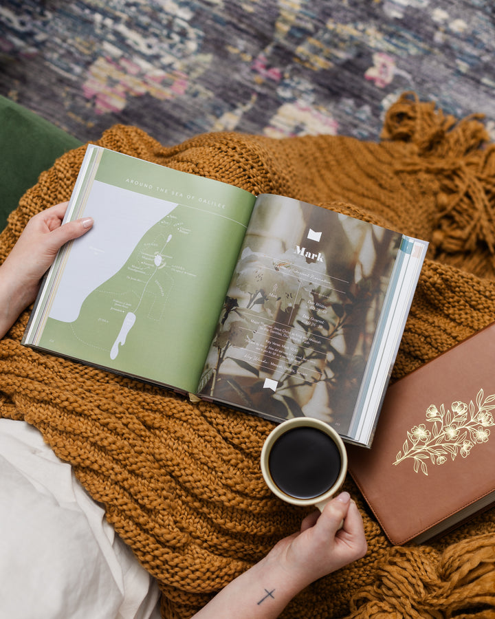 Inside of The Bible Handbook and women holding a up of coffee