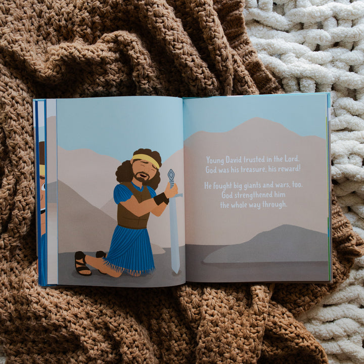 Brave in the Battle book opened to David praying to God page laying on a brown knitted blanket and a white knitted blanket