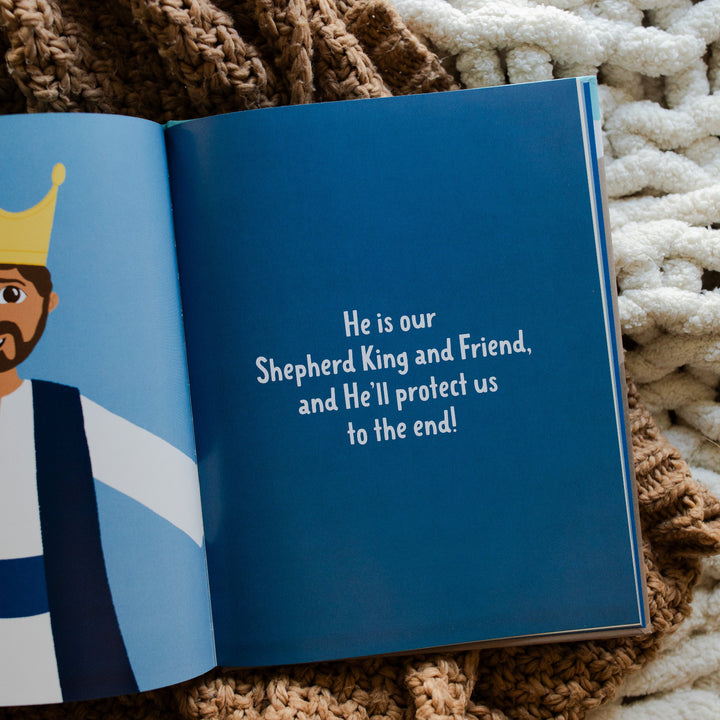 Brave in the Battle book opened to wording about Jesus is our king page laying on a brown knitted blanket and a white knitted blanket