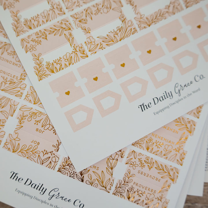 Stack of 'The Daily Grace Co' cards with gold designs and text.