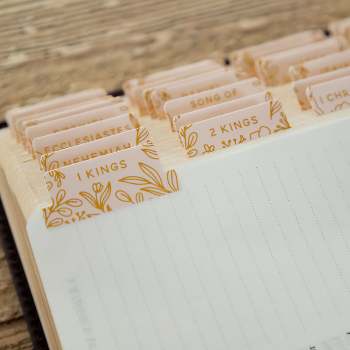 Open notebook with gold-inked dividers on a wooden surface